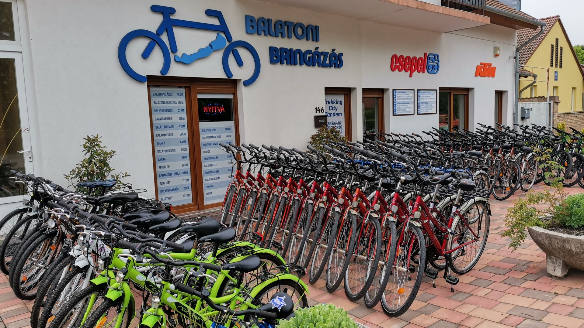 A Bike Balaton kerékpárkölcsönző üzlete, sorba állított bérelhető kerékpárokkal